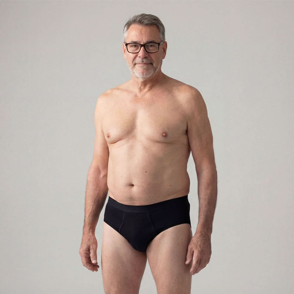 Senior man wearing black Orykas absorbent briefs against a neutral background, highlighting discreet and elegant underwear designed for light to moderate bladder leaks, providing everyday comfort, support, and invisible protection.